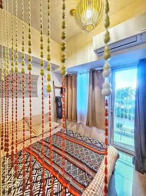 a room with a bed and a chandelier at That Boho Crib 1bedroom with Balcony facing amenities in Manila
