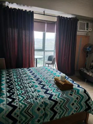 a bedroom with a bed with a quilt on it at Room Across NAIA Terminal 3 Two palm tree in Manila