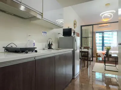 a kitchen with a counter and a refrigerator at 1BR Makati, Air Residences M008 in Manila
