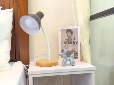 a lamp on a night stand next to a bed at 1BR Makati, Air Residences M008 in Manila