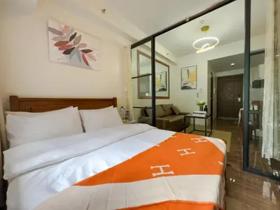 a bedroom with a large bed and a living room at 1BR Makati, Air Residences M008 in Manila
