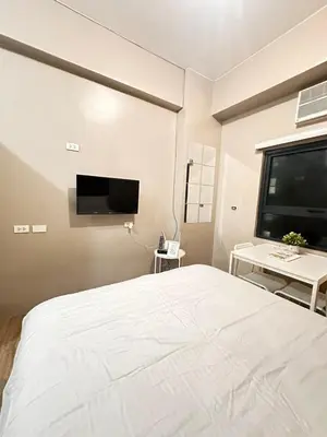 a bedroom with a large bed and a flat screen tv at S&Rs Place Space taft condominium in Manila