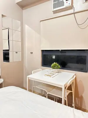 a white dining room with a white table and chairs at S&Rs Place Space taft condominium in Manila