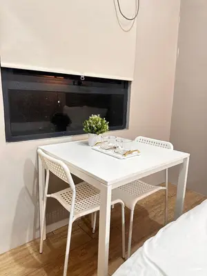a white dining room table with two chairs and a window at S&Rs Place Space taft condominium in Manila