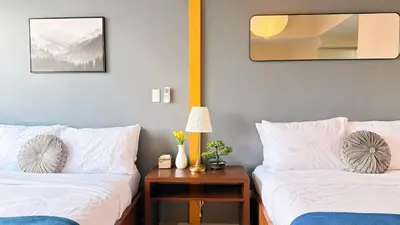 two beds in a room with a table and a mirror at BGC High Rise, Uptown Mall Link, 5G WiFi, Pool, Ste 29 in Manila