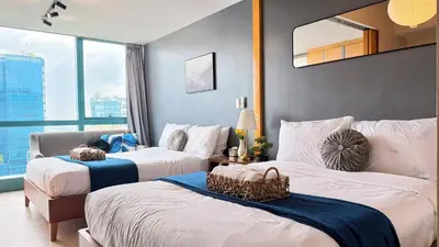 a hotel room with two beds and a window at BGC High Rise, Uptown Mall Link, 5G WiFi, Pool, Ste 29 in Manila