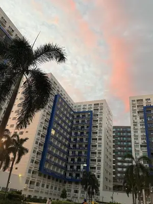 a tall building with a palm tree in front of it at Eriel condotel in Manila
