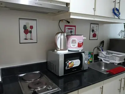 a kitchen with a microwave and a sink at Eriel condotel in Manila