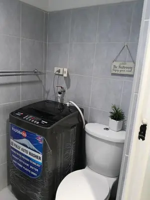 a bathroom with a toilet and a trash can at Eriel condotel in Manila