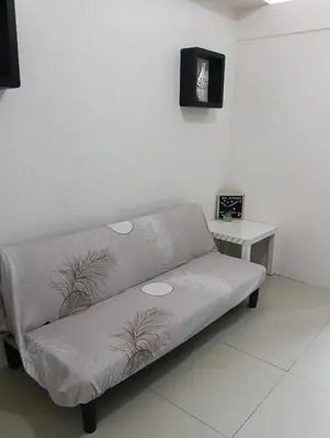 a gray couch in a room with a table at Eriel condotel in Manila