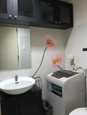 a bathroom with a sink and a flower on the wall at Eriel condotel in Manila