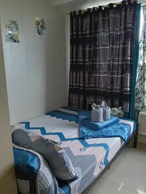 a bed in a room with a curtain at Eriel condotel in Manila