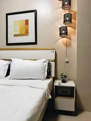 a bedroom with a bed and a night stand with a lamp at The Serenity Studio in Manila