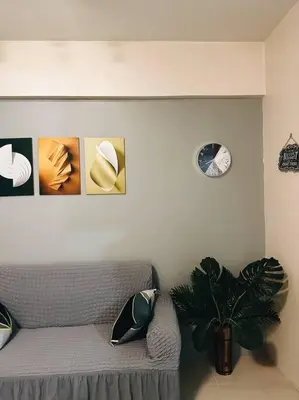 a living room with a couch and a clock on the wall at The Serenity Studio in Manila