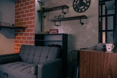 a living room with a couch and a clock on the wall at Comfy and Cozy Retreat in Manila with a Stunning View in Manila
