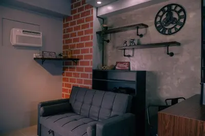 a living room with a couch and a brick wall at Comfy and Cozy Retreat in Manila with a Stunning View in Manila
