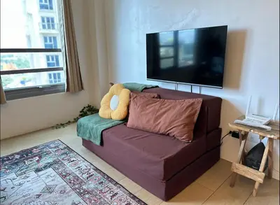 a living room with a purple couch with a teddy bear at Studio in Eastwood Fast Wifi Free Pool & Gym in Manila
