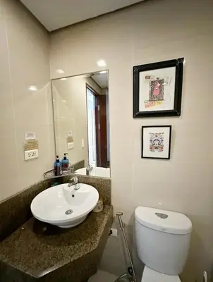 a bathroom with a sink and a toilet and a mirror at Studio in Eastwood Fast Wifi Free Pool & Gym in Manila