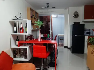 a kitchen with a red table and a red stool at bendetto residences in Manila
