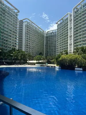 a large swimming pool in front of a large building at Dwell at Azure Urban Resort Residences Bahamas Tower in Manila