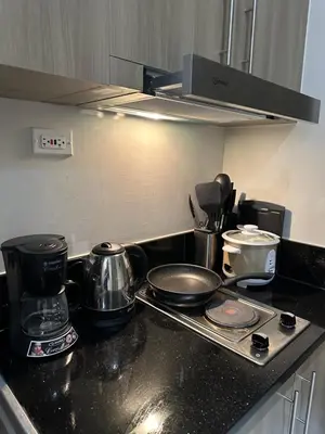 a kitchen counter with pots and pans on a stove at Casa ni Yanyan at Fame Residences in Manila