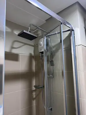 a shower with a glass door in a bathroom at Casa ni Yanyan at Fame Residences in Manila