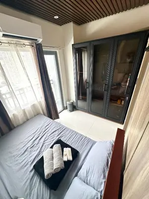 a bedroom with a bed with two towels on it at Casa ni Yanyan at Fame Residences in Manila