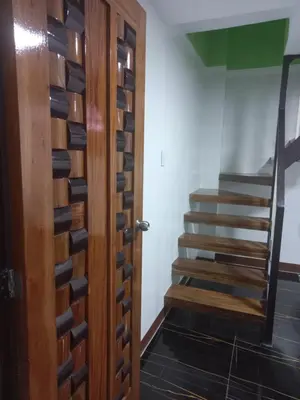 a room with a wooden door and a staircase at Joshua Transient in Manila