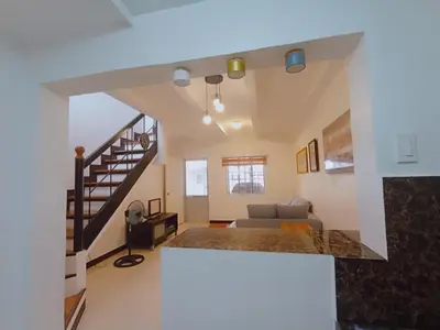 a living room with a couch and a staircase at JeSa's Serenity Sanctuary in Dasmariñas
