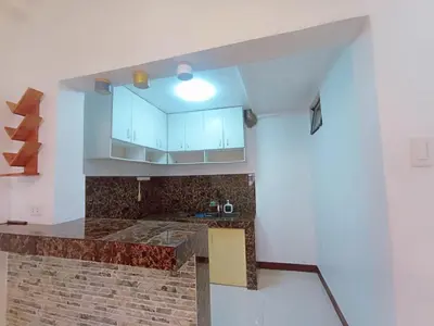 a kitchen with white cabinets and a brick wall at JeSa's Serenity Sanctuary in Dasmariñas