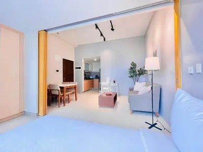 a bedroom with a bed and a living room at One Uptown Residence BGC in Manila