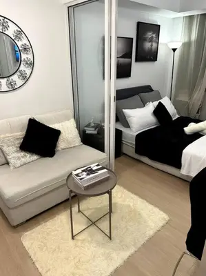 a living room with a couch and a mirror at El Spacio Azure 1BR with PS4 & Netflix in Manila