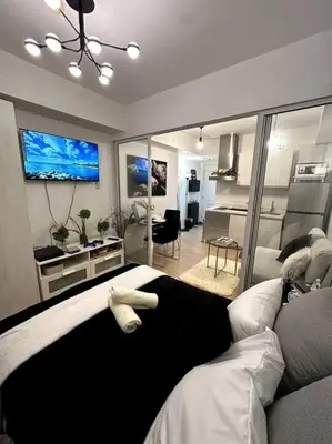 a living room with a couch and a tv at El Spacio Azure 1BR with PS4 & Netflix in Manila