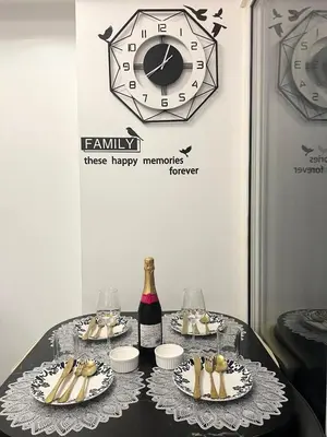 a table with plates of food and a clock on a wall at Affordable Azure Staycation in Manila