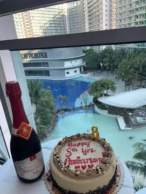 a birthday cake sitting next to a bottle of champagne at Affordable Azure Staycation in Manila