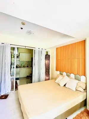 a bedroom with a large bed and a kitchen at Casa Marix & Z - Beach View Unit in Manila