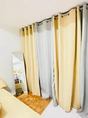 a bedroom with yellow and white curtains and a mirror at Casa Marix & Z - Beach View Unit in Manila