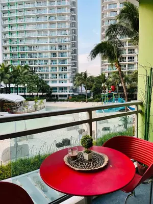 a red table on a balcony with a view of the ocean at Casa Marix & Z - Beach View Unit in Manila