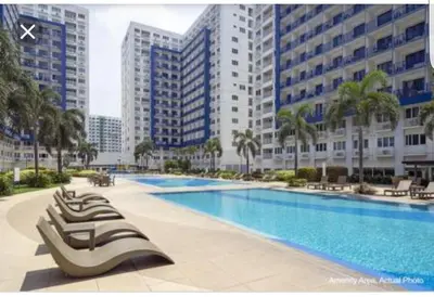a swimming pool in a city with tall buildings at Staycation at Sea Residences Suite B1202 in Manila