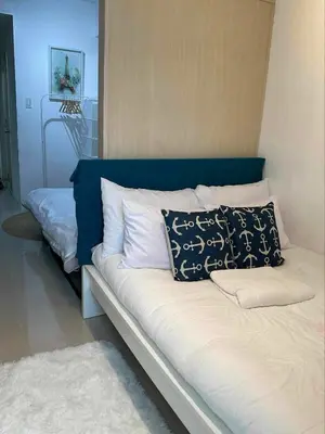 a bed with two pillows on it in a room at Staycation at Sea Residences Suite B1202 in Manila