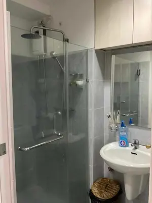 a bathroom with a shower and a sink at Staycation at Sea Residences Suite B1202 in Manila