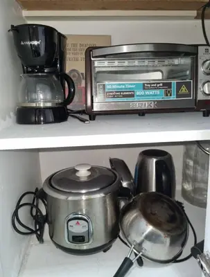 a slow cooker and a toaster on a shelf at Staycation at Sea Residences Suite B1202 in Manila