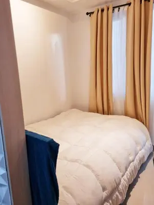 a small bed in a room with a window at Staycation at Sea Residences Suite B1202 in Manila