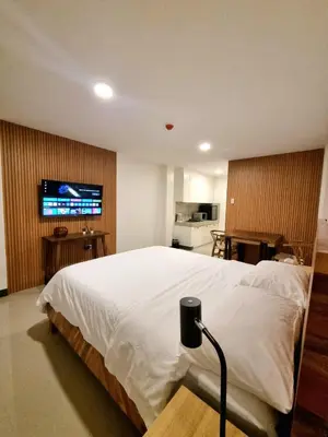 a bedroom with a bed with a tv on the wall at Flat 35, Unit 1E in Manila