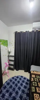 a bedroom with a black curtain and a bed at STAYCATION near MOA in Manila