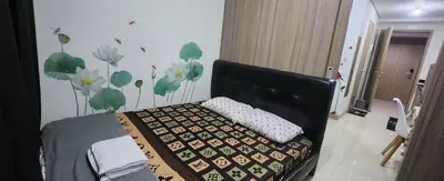 a bedroom with a bed with a black headboard and flowers on the wall at STAYCATION near MOA in Manila