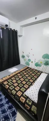 a room with a bed with a rug on the floor at STAYCATION near MOA in Manila