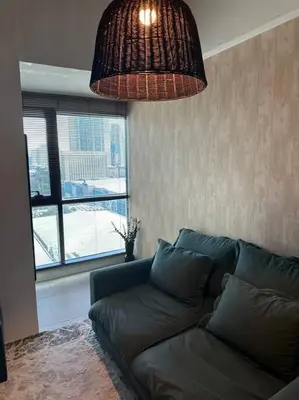 a couch in a living room with a large window at 1br wNetflix Disneyplus and pool across SM Megamall Ortigas CBD in Manila