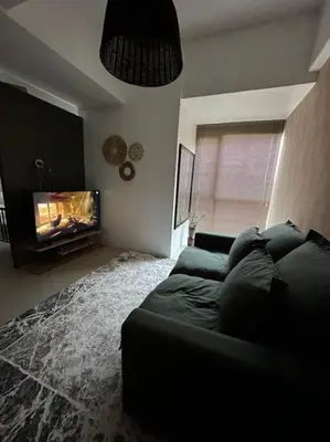 a living room with a couch and a tv at 1br wNetflix Disneyplus and pool across SM Megamall Ortigas CBD in Manila