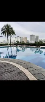 a large swimming pool with a city in the background at Quaint Aparthotel T22306 in Manila